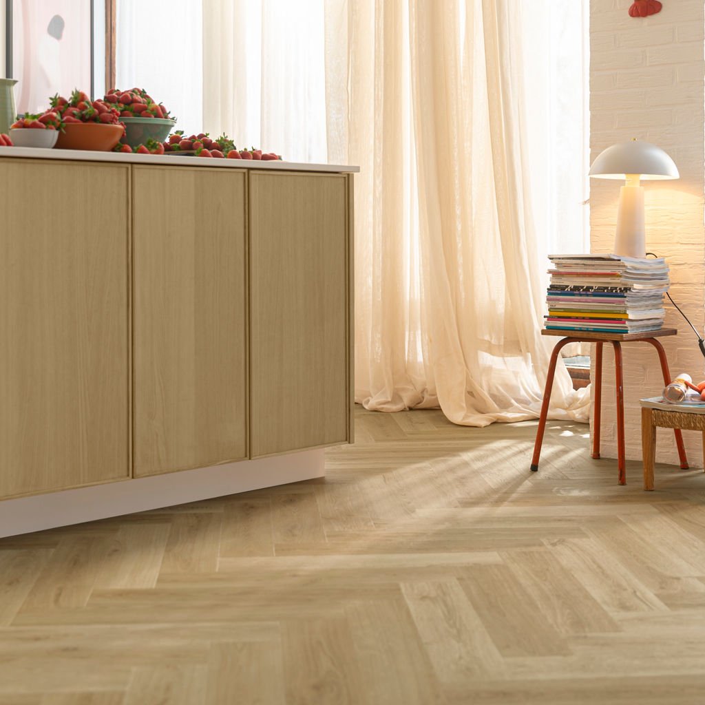 Herringbone flooring laid across a bright living space, showing the pattern at full scale