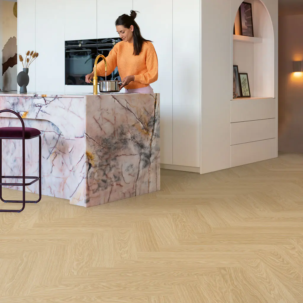 Herringbone luxury vinyl flooring in a modern kitchen with a marble island