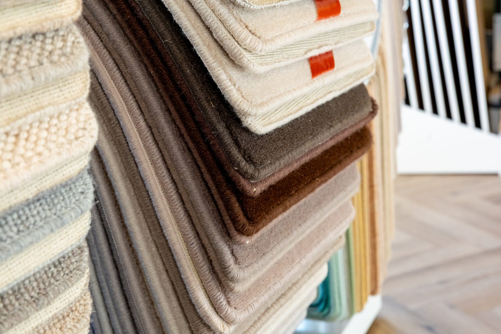 Stacked carpet samples in neutral tones including beige, brown, grey textures - royalflooringcompany.ie